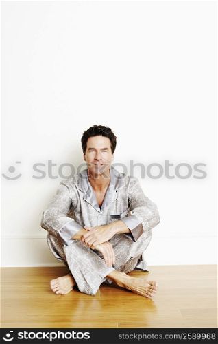 Portrait of a mature man sitting cross-legged on the floor