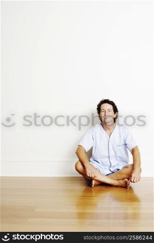 Portrait of a mature man sitting cross-legged on the floor and smiling