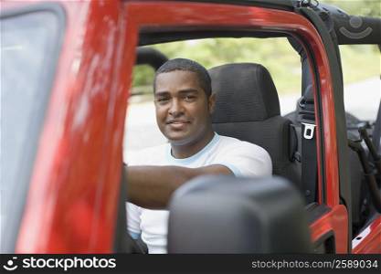 Portrait of a mature man sitting in a jeep