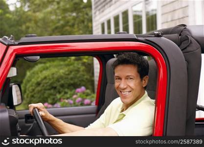 Portrait of a mature man sitting in a sports utility vehicle and smiling