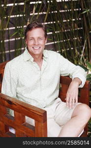 Portrait of a mature man sitting in an armchair and smiling