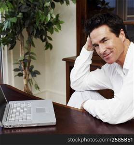 Portrait of a mature man sitting in front of a laptop