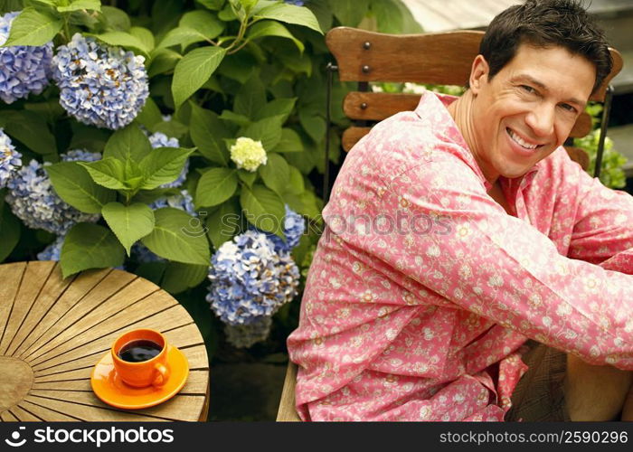 Portrait of a mature man sitting on a chair and smiling