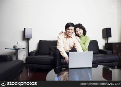 Portrait of a mature man sitting on a couch with a mature woman using a laptop