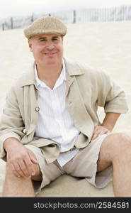 Portrait of a mature man sitting on the beach and smiling