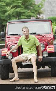 Portrait of a mature man sitting on the bumper of a jeep