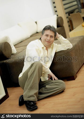 Portrait of a mature man sitting on the floor and smiling