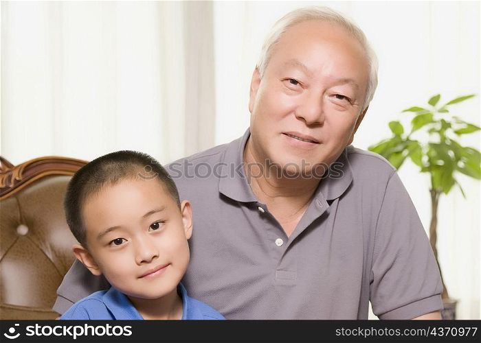 Portrait of a mature man sitting with his grandson