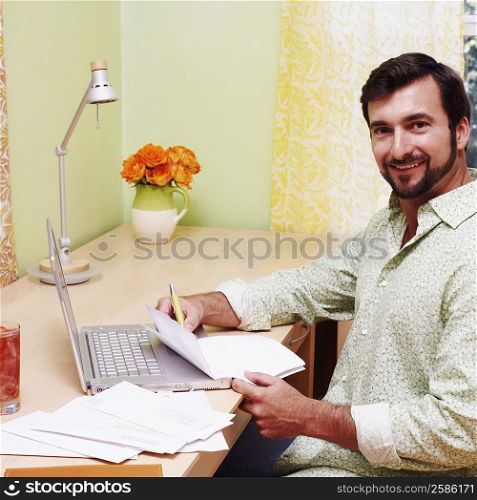 Portrait of a mature man smiling and holding a document