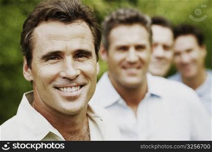 Portrait of a mature man smiling with his friends in the background