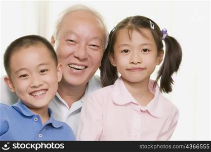 Portrait of a mature man smiling with his grandchildren
