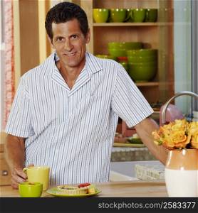 Portrait of a mature man standing in a kitchen and smiling