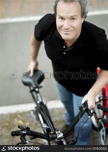 Portrait of a mature man standing with a bicycle
