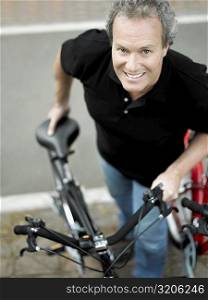Portrait of a mature man standing with a bicycle and smiling