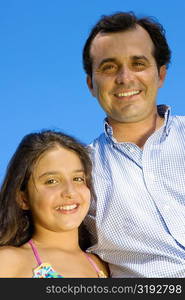 Portrait of a mature man standing with his daughter and smiling