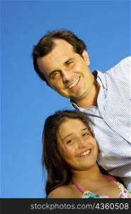 Portrait of a mature man standing with his daughter and smiling