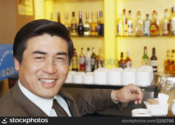 Portrait of a mature man stirring a cup of coffee