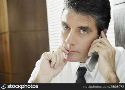 Portrait of a mature man talking on a mobile phone and thinking