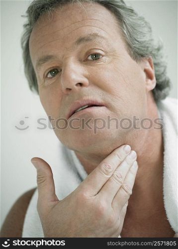 Portrait of a mature man touching his neck