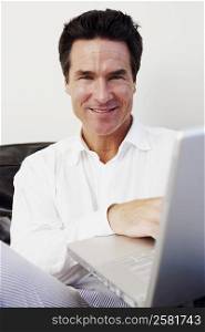 Portrait of a mature man using a laptop and smiling