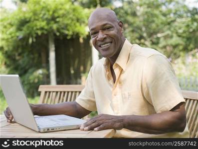 Portrait of a mature man using a laptop and smiling