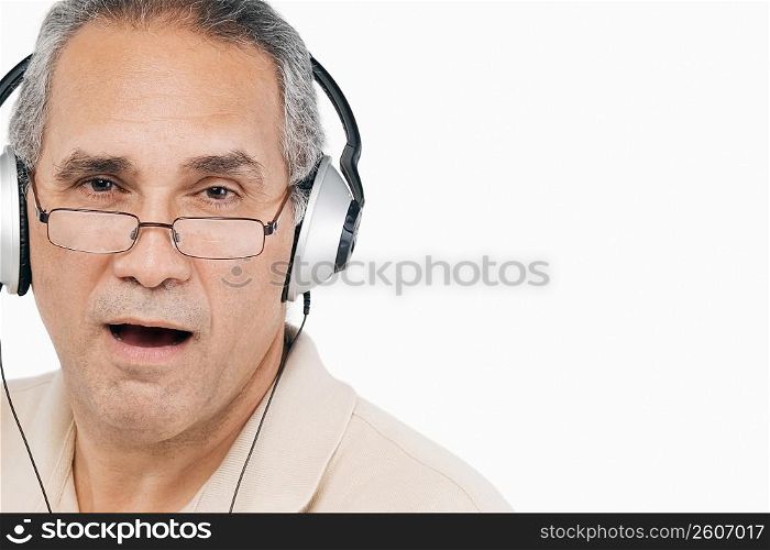 Portrait of a mature man wearing headphones and singing