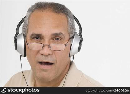 Portrait of a mature man wearing headphones and singing