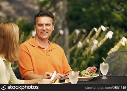 Portrait of a mature man with a mid adult woman sitting at the table