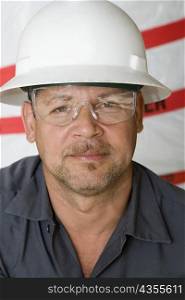 Portrait of a mature man with a pair of protective eyewear and a hardhat