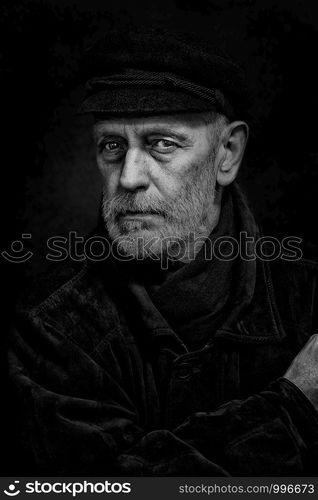 Portrait of a mature man with a white beard and a cap on the head. He could be a sailor, a worker, a docker, or even a gangster or a thug. He has a penetrating gaze.