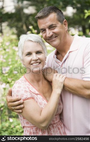 Portrait of a mature man with arm around his wife and smiling
