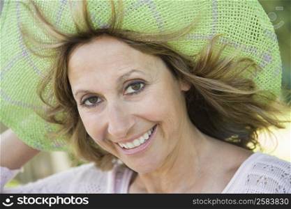 Portrait of a mature woman adjusting her hat and smiling