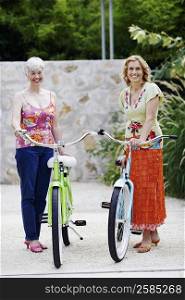 Portrait of a mature woman and a senior woman standing with bicycles