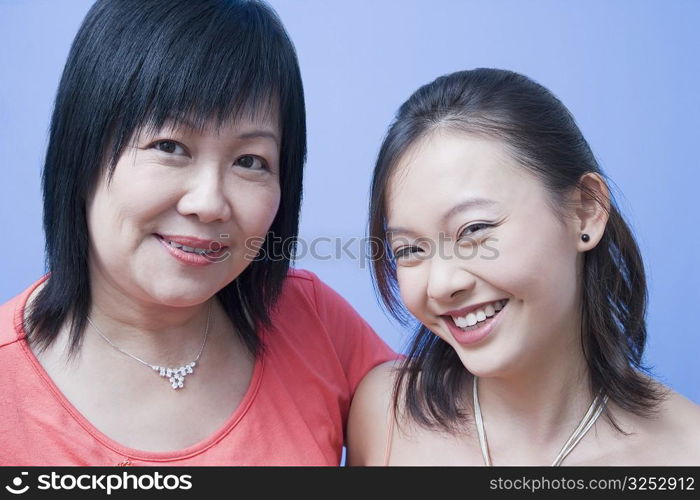 Portrait of a mature woman and her daughter smiling