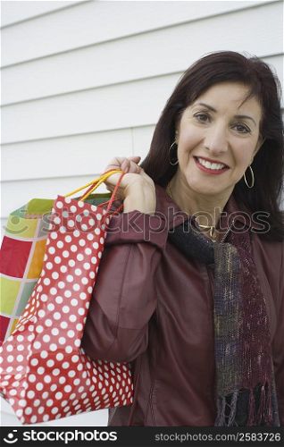 Portrait of a mature woman carrying shopping bags and smiling