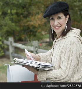 Portrait of a mature woman checking mails and smiling