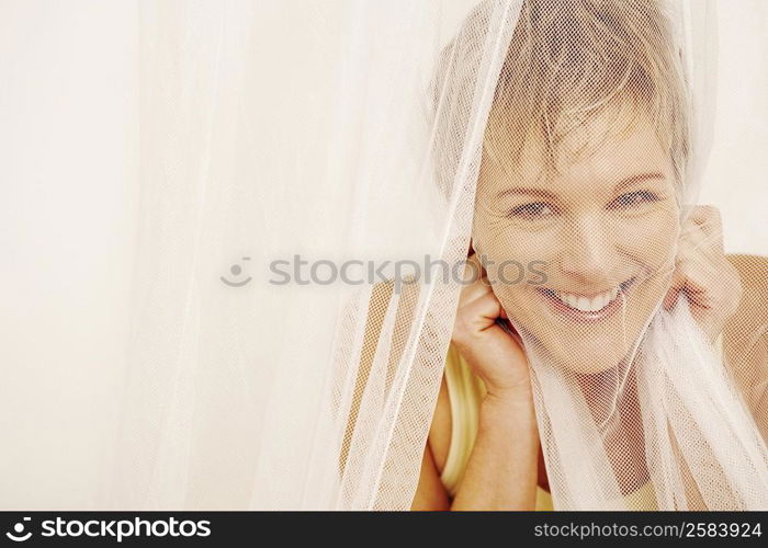 Portrait of a mature woman covering her face with a mosquito net