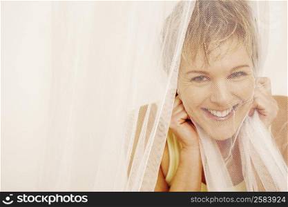 Portrait of a mature woman covering her face with a mosquito net