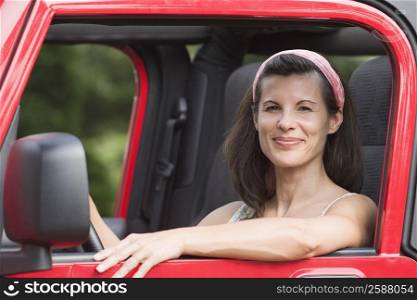 Portrait of a mature woman driving a jeep and smiling