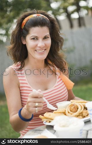 Portrait of a mature woman eating snacks and smiling