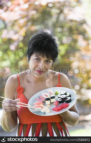 Portrait of a mature woman eating sushi with chopsticks