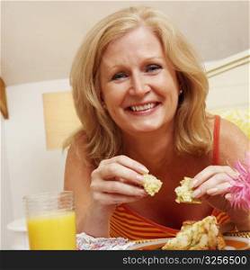 Portrait of a mature woman having breakfast in bed