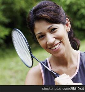 Portrait of a mature woman holding a badminton racket and smiling