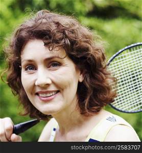 Portrait of a mature woman holding a badminton racket and smiling