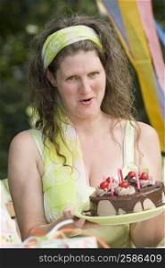 Portrait of a mature woman holding a birthday cake