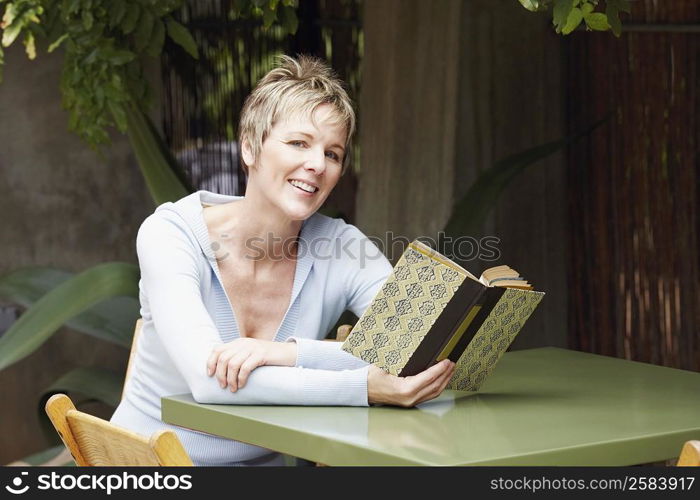 Portrait of a mature woman holding a book and smiling