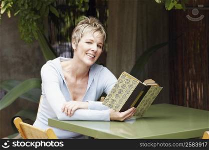 Portrait of a mature woman holding a book and smiling