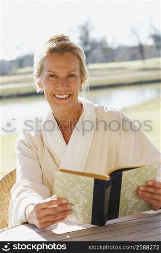 Portrait of a mature woman holding a book and smiling