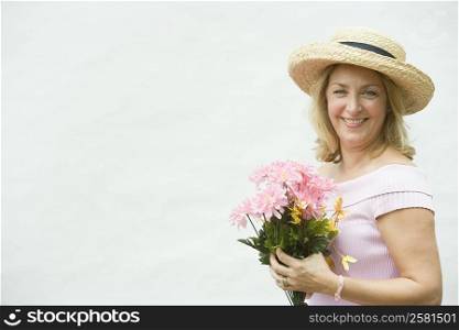 Portrait of a mature woman holding a bouquet of flowers and smiling