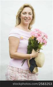 Portrait of a mature woman holding a bouquet of flowers and smiling